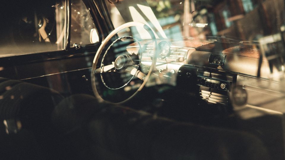Blick durch das Fenster auf das Amaturenbrett eines historischen Autos