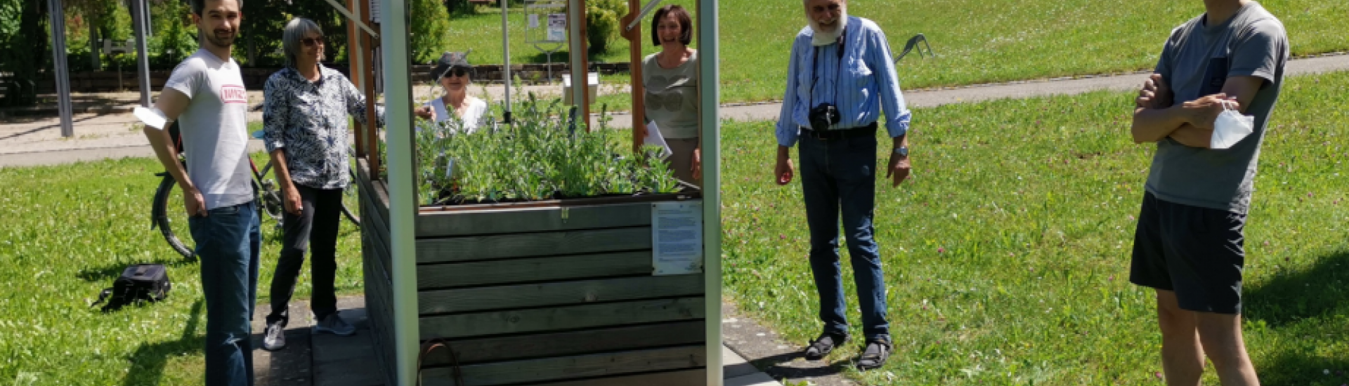 6 verschiedene Personen stehen vor einem digital ausgerüsteten Hochbeet